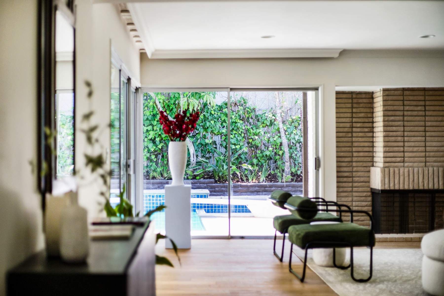 Living room with pool view and green lounge chairs